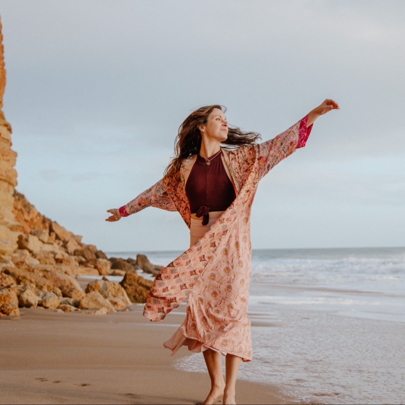 Élise Pieters, bras ouverts, kimono rose au vent